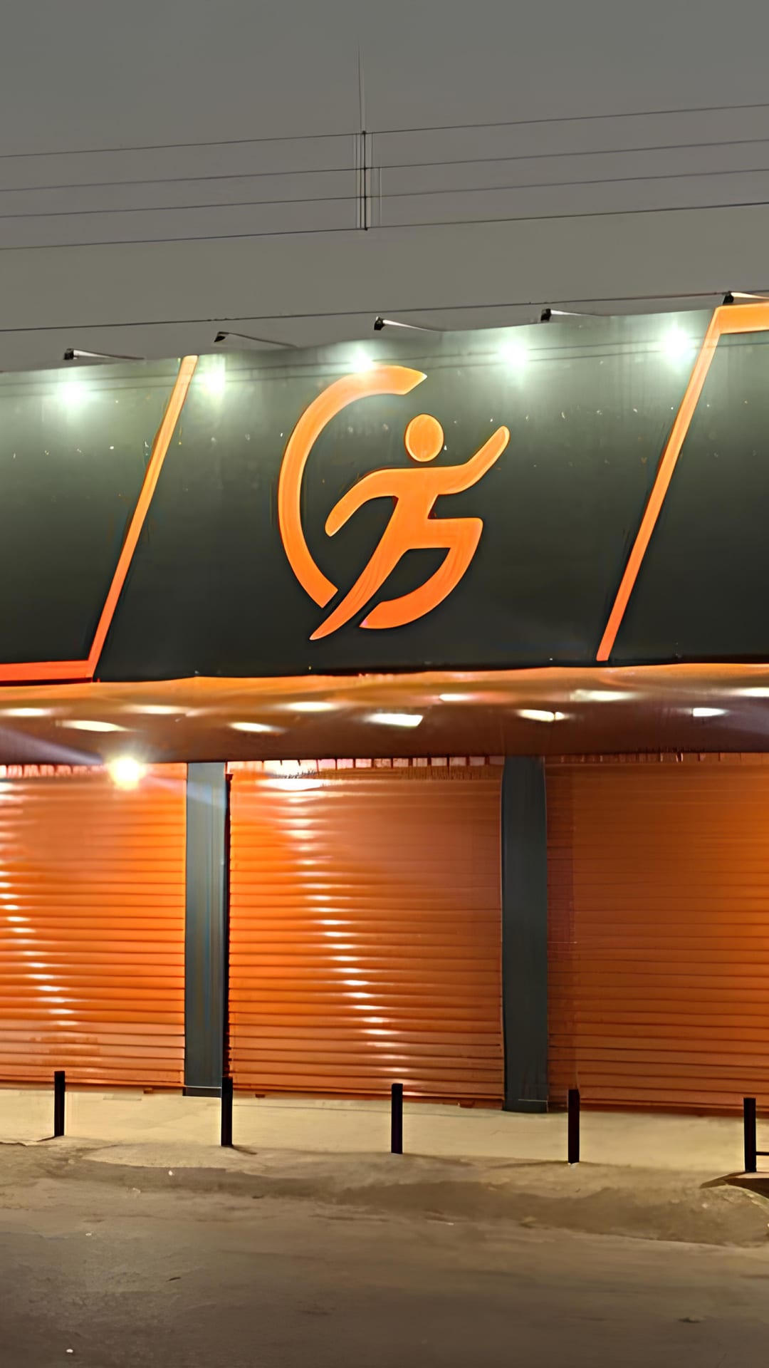 Fachada iluminada da GFIT Academia vista da Avenida Entrada, em Girassol